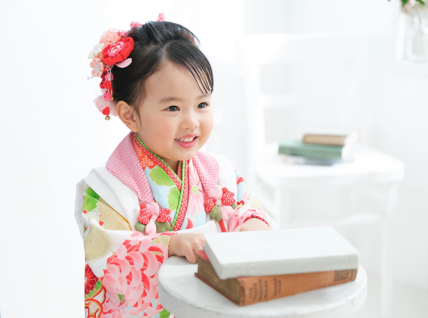 ピンクの着物を着て本を持つ女の子の七五三写真