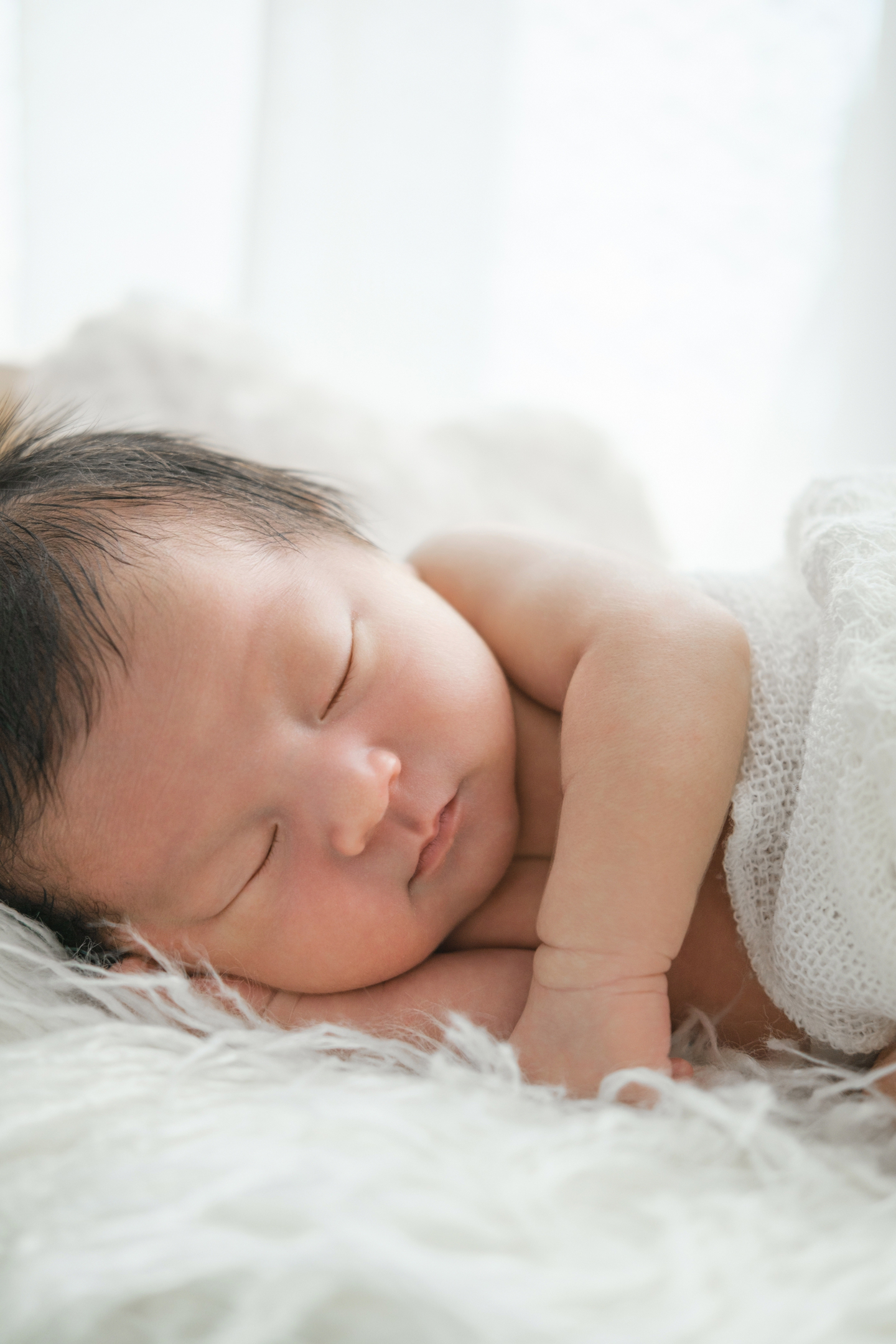 柔らかな光の中で眠る生まれたばかりの赤ちゃん