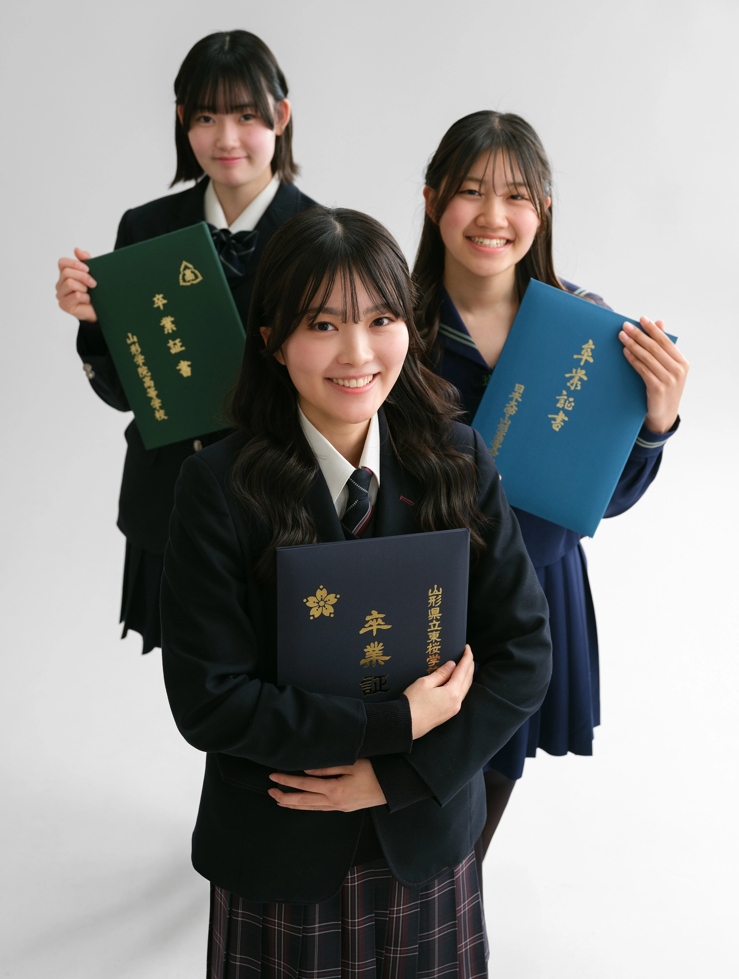 卒業証書を持った制服姿の3人