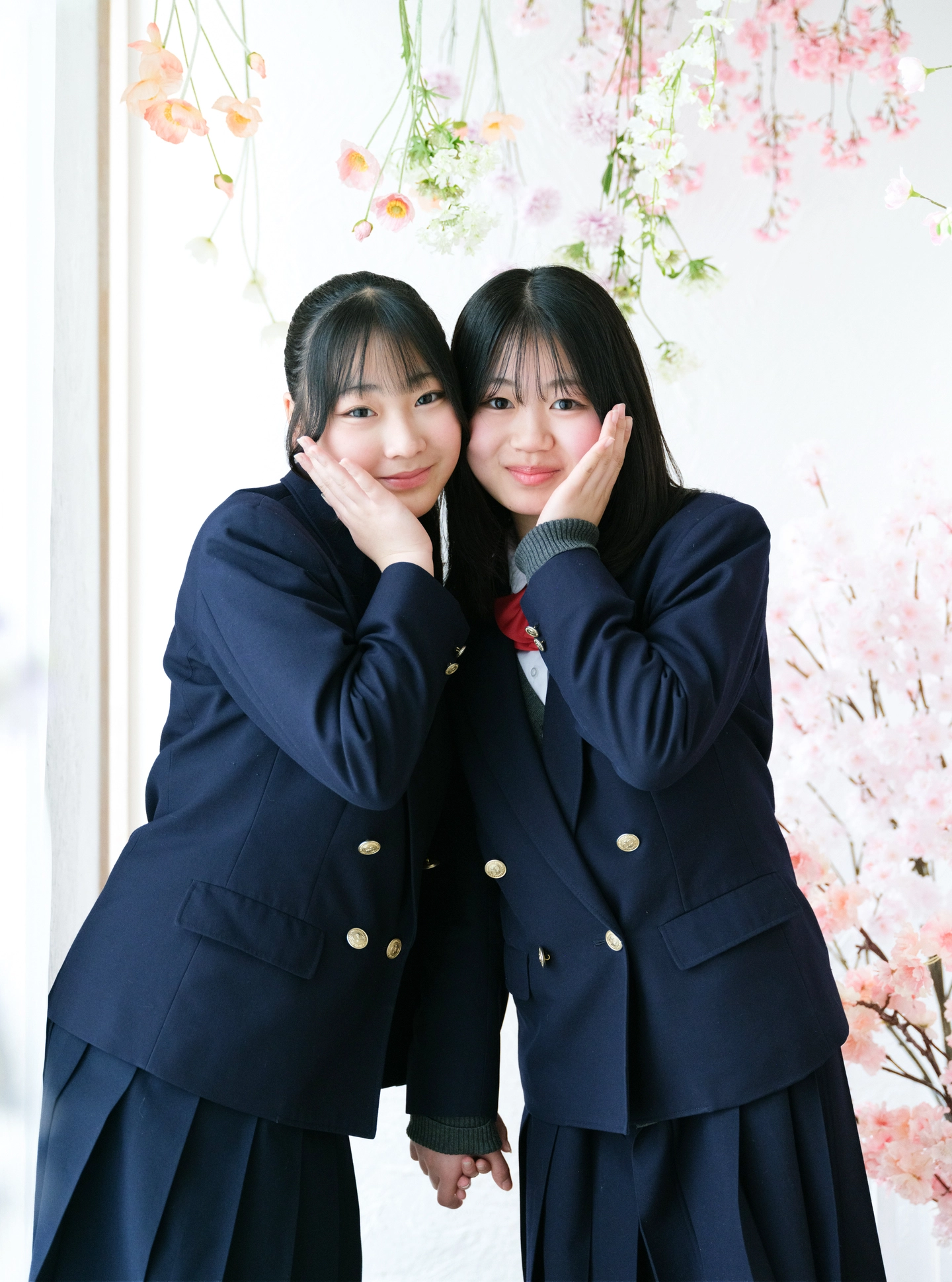 春の花を背景に寄り添う制服姿のお友達
