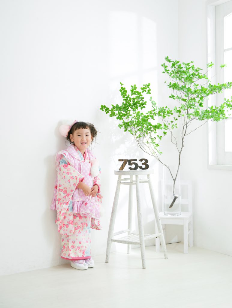 3歳の女の子が七五三の着物を着て笑顔で立つ姿