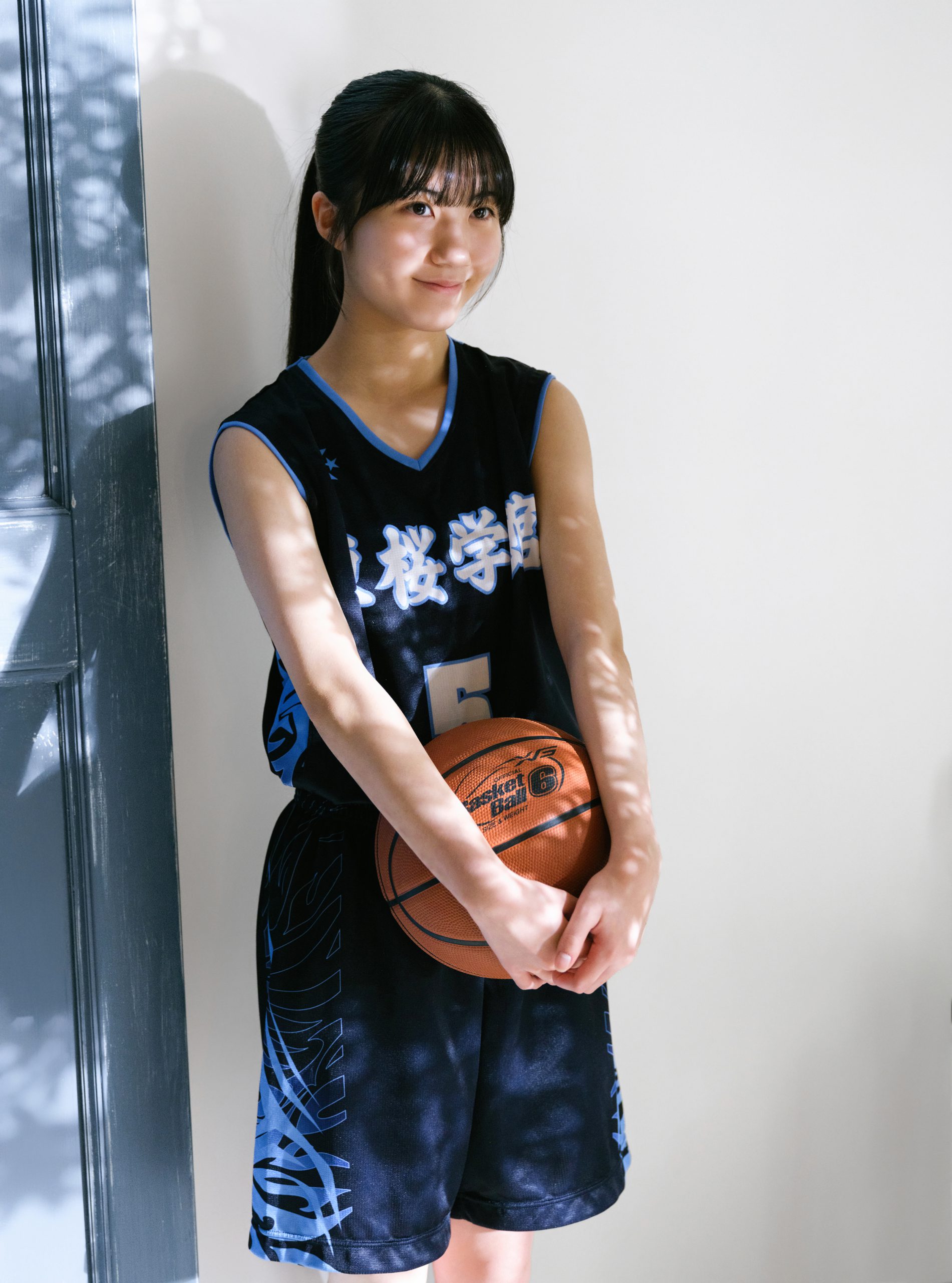 木漏れ日の中でバスケットボールを持つユニフォーム姿