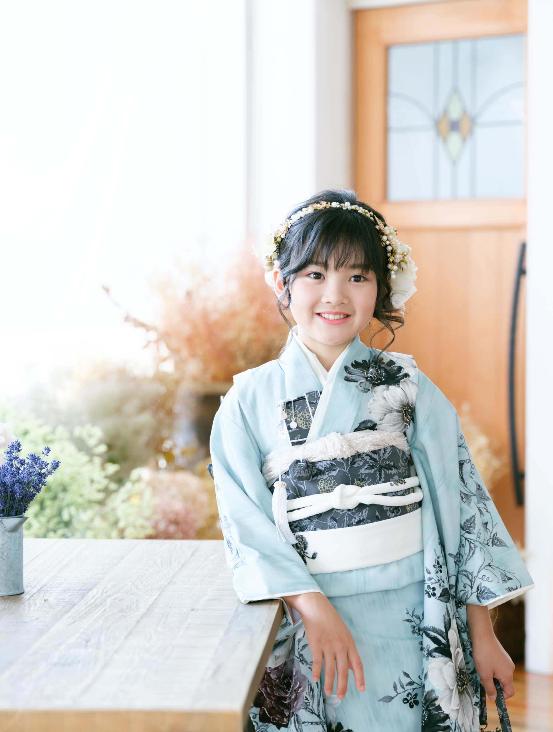 自然光のスタジオで笑顔を見せる7歳の七五三写真