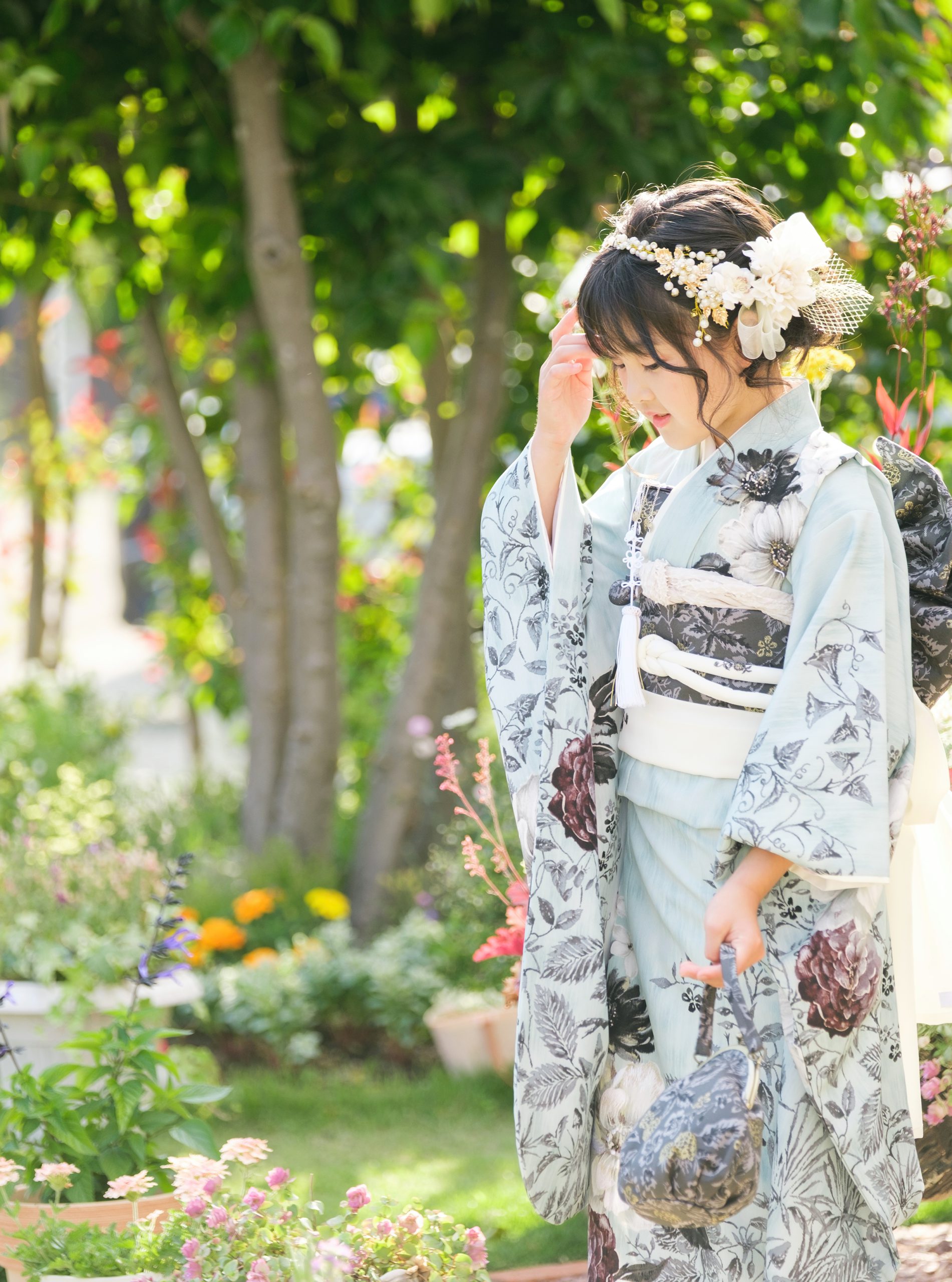 木漏れ日のガーデンで髪飾りと着物姿を見せる7歳の七五三