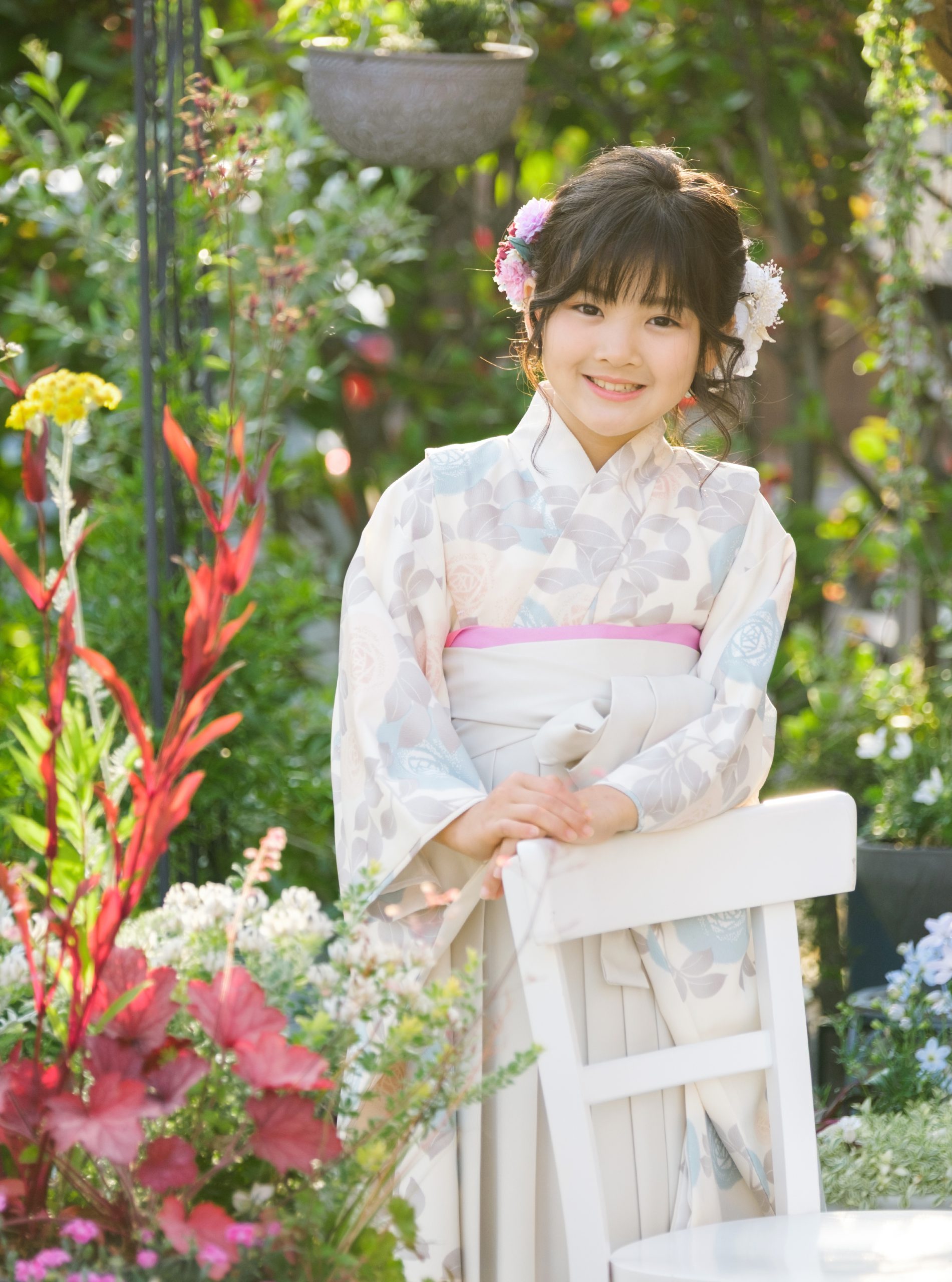 やわらかな光のガーデンで椅子に寄り添う七五三の着物姿
