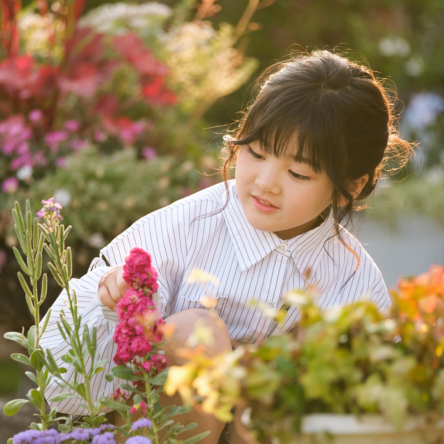 夕暮れのガーデンで花を眺める7歳の自然なポートレート