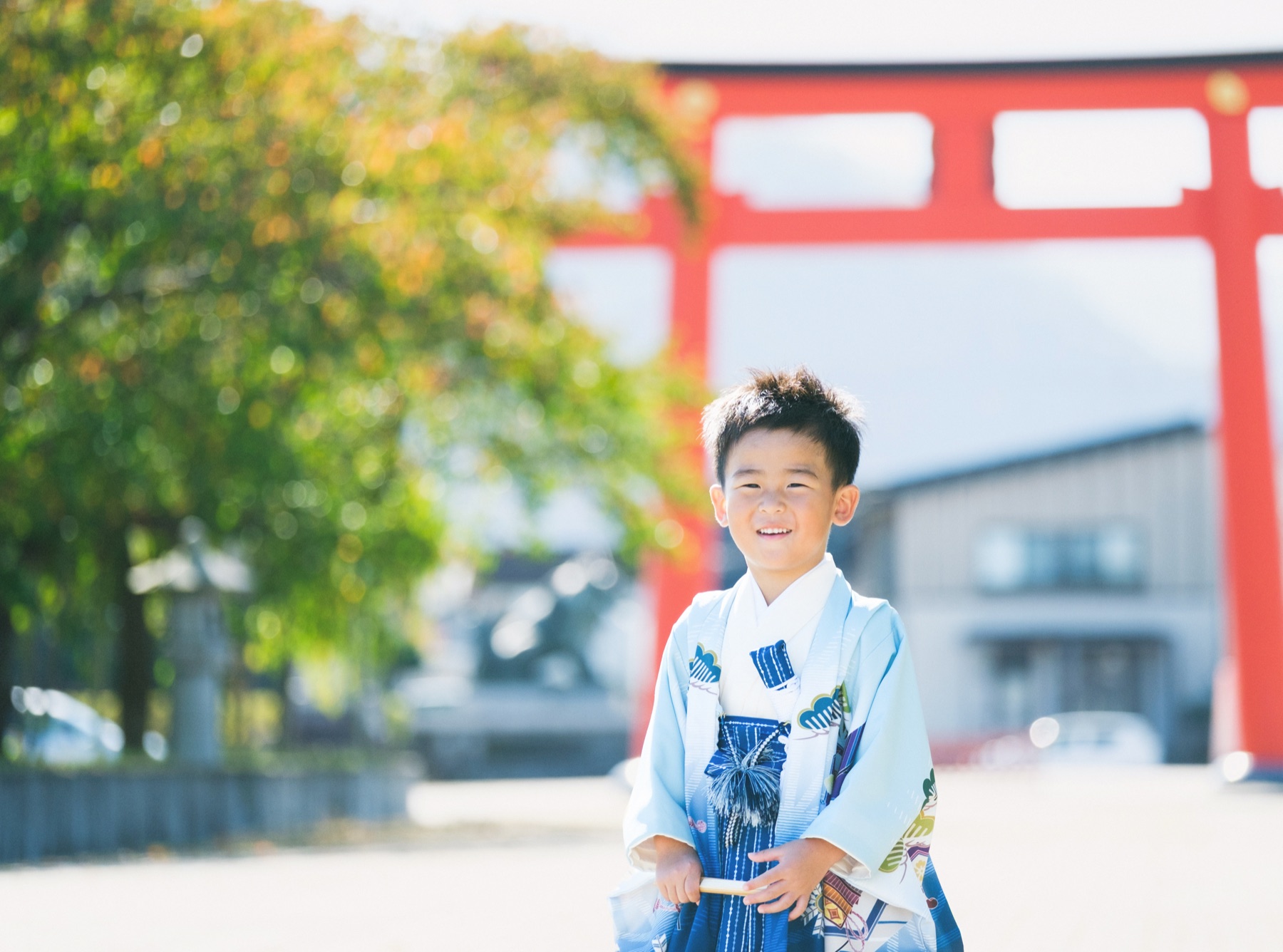 山形市の護国神社の赤い鳥居を背景に笑う、羽織袴姿の5歳の男の子