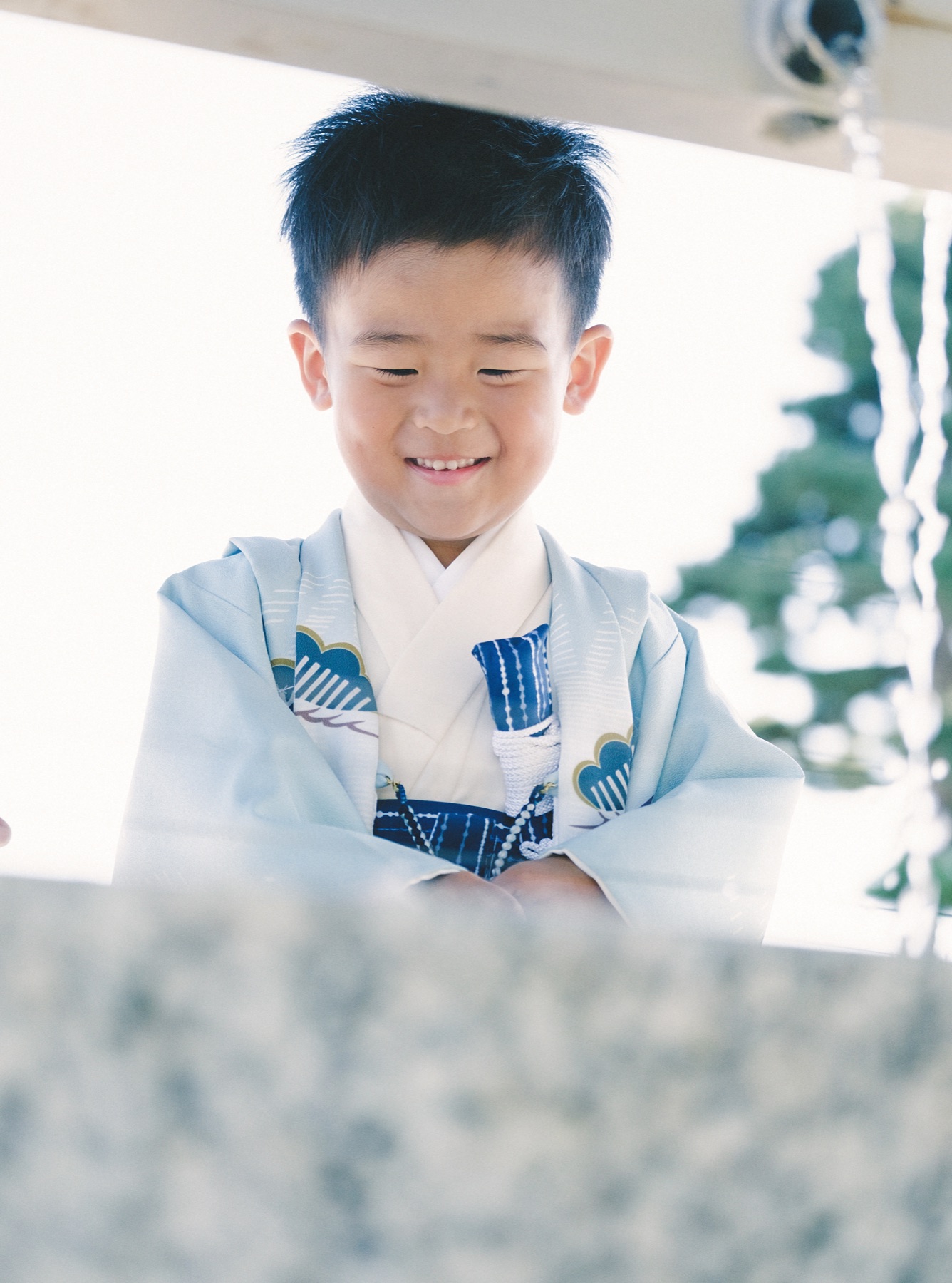 手水舎で手元を見ながら笑顔を見せる男の子